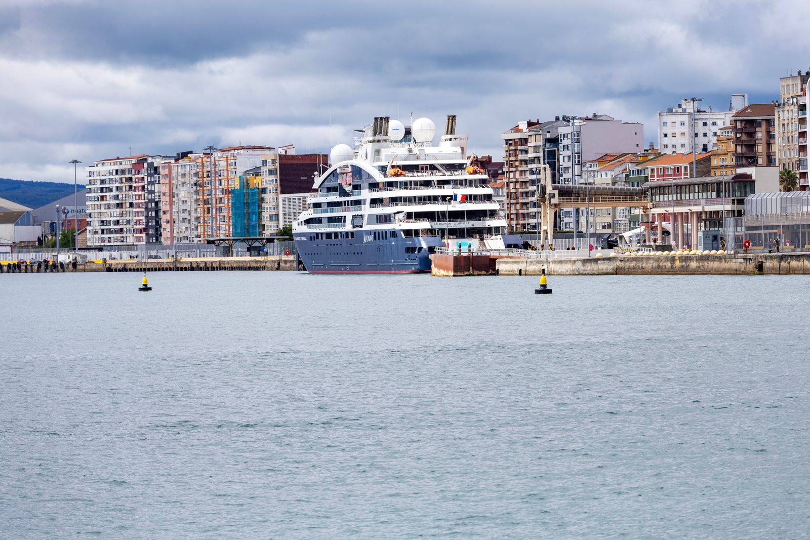 Small cruise ship moored in a city harbor, one end of the scale of cruise ship classes by size